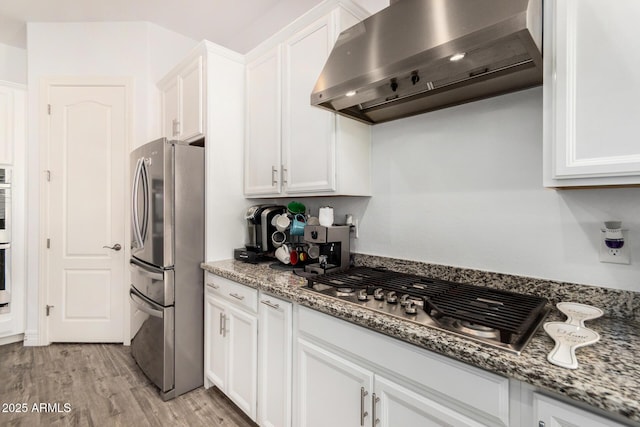 2052 E Scorpio Pl, Chandler, AZ 85249 - kitchen featuring wall chimney range hood, appliances with stainless steel finishes, white cabinets, light wood-style floors, and light stone counters