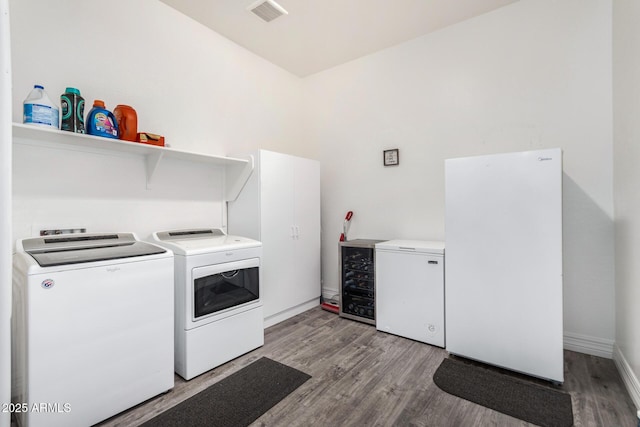 2052 E Scorpio Pl, Chandler, AZ 85249 - laundry area with washer and clothes dryer, light wood-type flooring, wine cooler, and baseboards