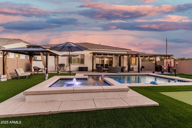 2052 E Scorpio Pl, Chandler, AZ 85249 - pool at dusk with a putting area, a gazebo, a patio area, a fenced backyard, and an outdoor hangout area
