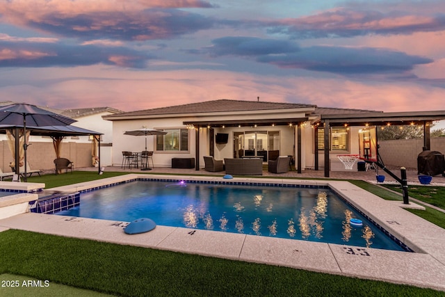 2052 E Scorpio Pl, Chandler, AZ 85249 - pool at dusk with an outdoor living space, a gazebo, a patio area, and a fenced backyard