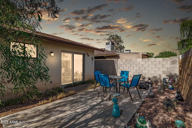 1807 E Jamaica Ave, Mesa, AZ 85204 - patio terrace at dusk featuring a patio, a fenced backyard, and outdoor dining space