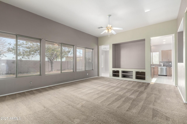 unfurnished living room with ceiling fan and light carpet