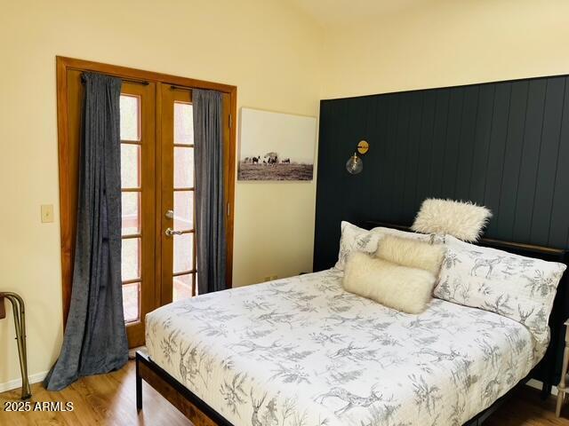 bedroom featuring french doors and wood finished floors