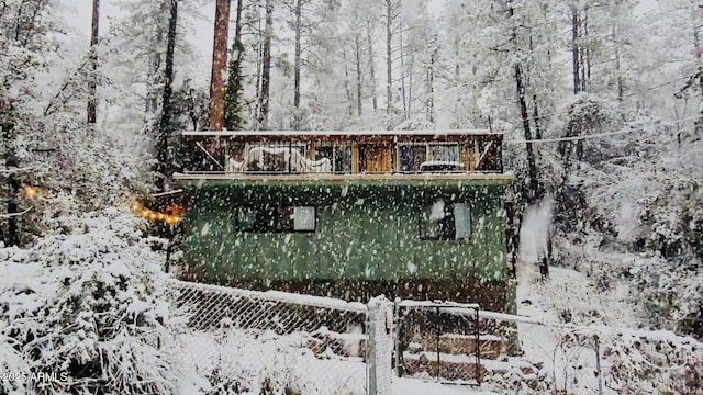 snow covered property featuring fence