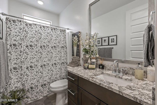 full bath featuring vanity, a shower with shower curtain, and toilet