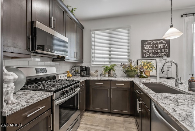 kitchen with backsplash, dark brown cabinets, stainless steel appliances, and a sink