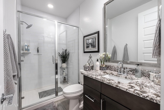 bathroom with vanity, toilet, and a shower stall