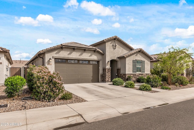 mediterranean / spanish home featuring stucco siding, stone siding, concrete driveway, a garage, and a tiled roof