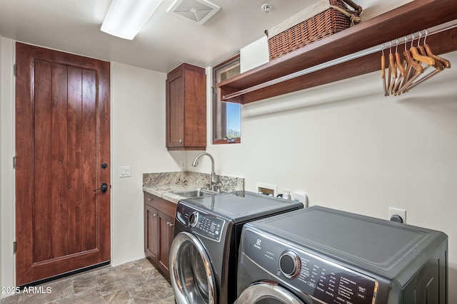 washroom featuring cabinets, sink, and washing machine and clothes dryer