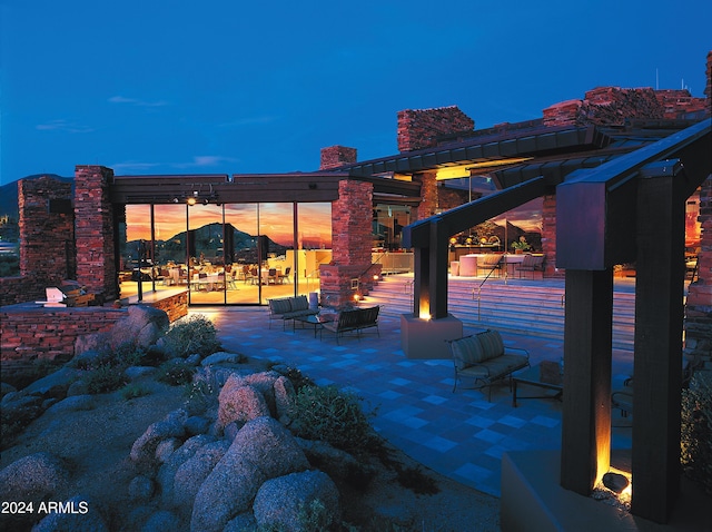 patio terrace at dusk featuring an outdoor living space with a fire pit