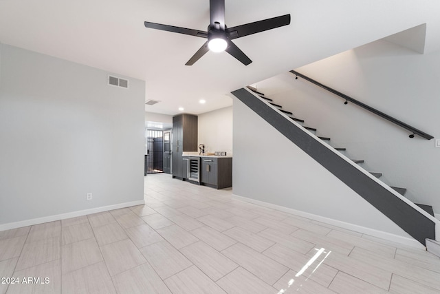 unfurnished living room featuring ceiling fan and wine cooler