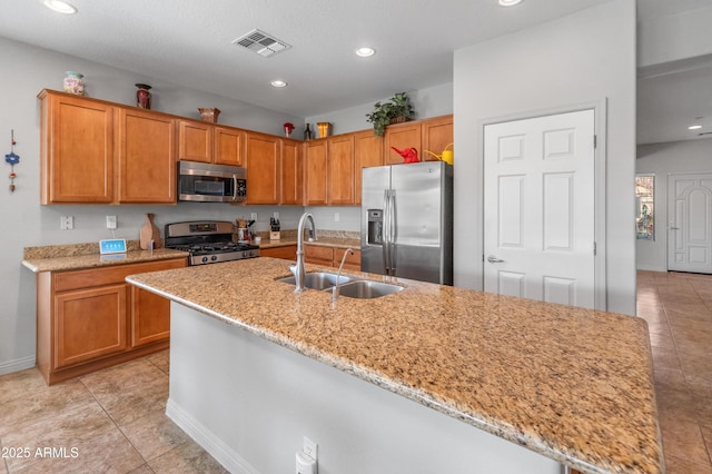 kitchen with visible vents, a sink, light stone counters, recessed lighting, and stainless steel appliances