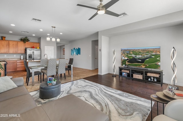 living room featuring recessed lighting, visible vents, light wood-style flooring, and baseboards