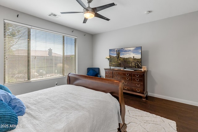 bedroom with visible vents, baseboards, wood finished floors, and a ceiling fan