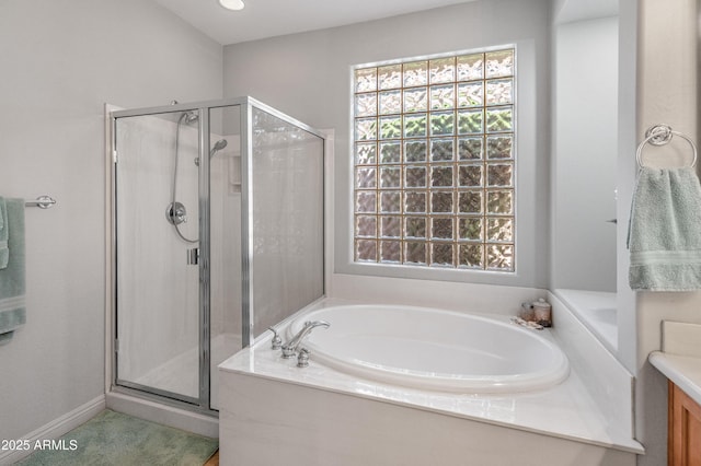 bathroom with a stall shower, vanity, and a garden tub