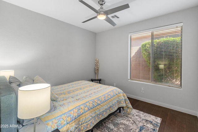 bedroom with visible vents, baseboards, wood finished floors, and a ceiling fan