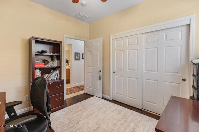 office area with baseboards, visible vents, dark wood-style flooring, and ceiling fan