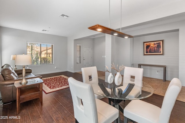 dining space with visible vents, baseboards, and wood finished floors