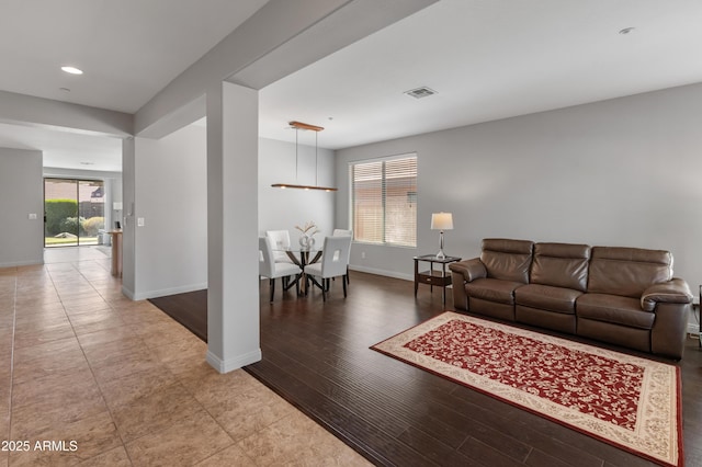 living area featuring recessed lighting, visible vents, baseboards, and wood finished floors