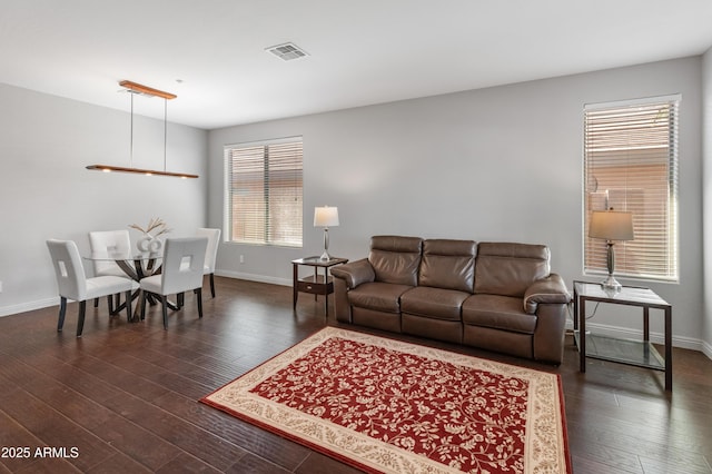 living area with visible vents, baseboards, and dark wood-style flooring