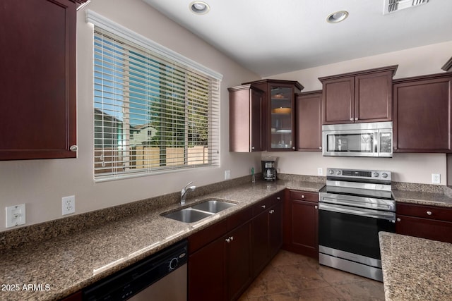 kitchen featuring recessed lighting, stainless steel appliances, a sink, visible vents, and glass insert cabinets