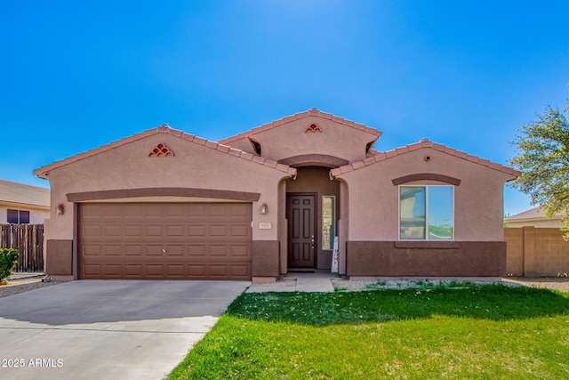 mediterranean / spanish home featuring fence, a garage, concrete driveway, a front lawn, and stucco siding