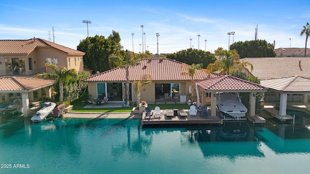 rear view of house with a water view and a patio