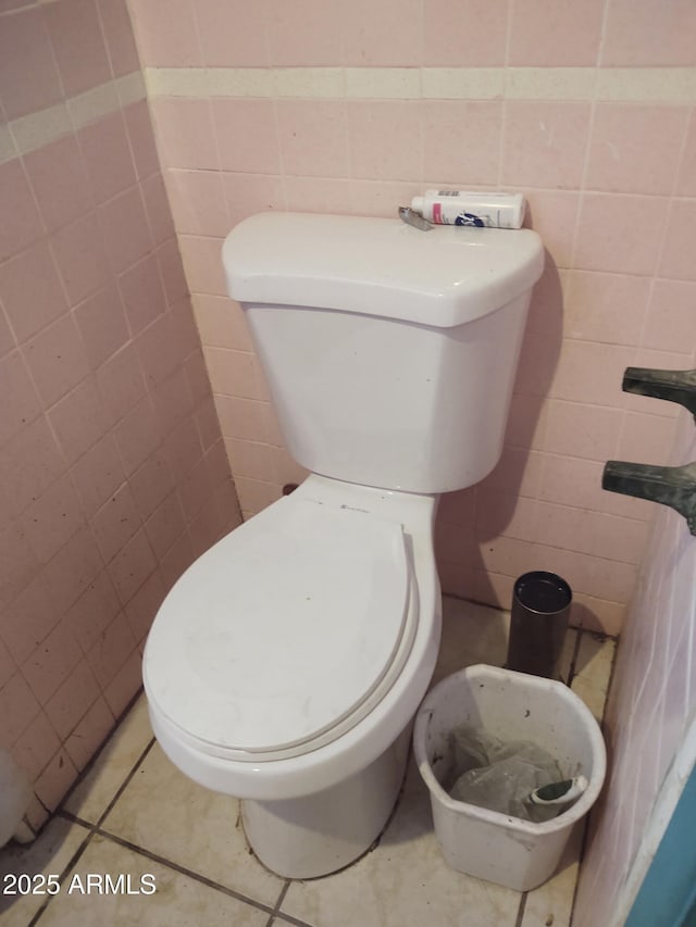 bathroom with tile walls, tile patterned floors, and toilet