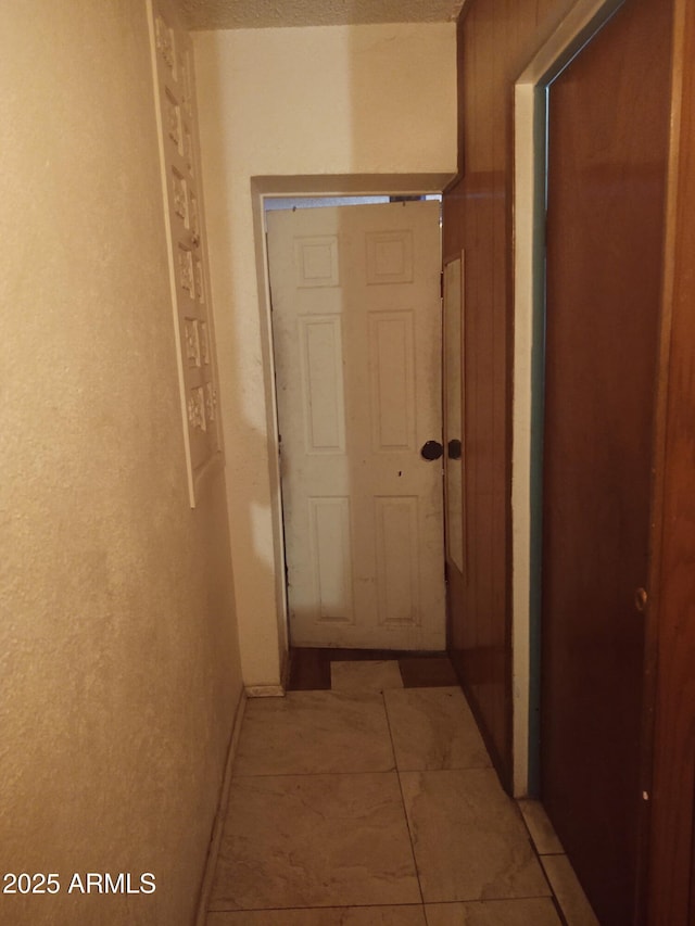 hallway featuring wood walls