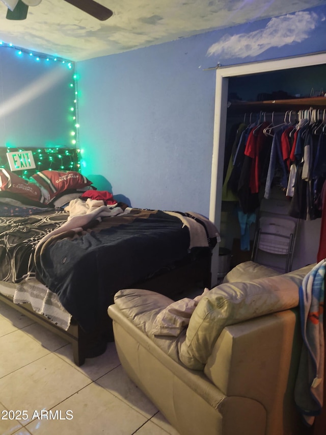 bedroom with light tile patterned floors, ceiling fan, and a closet