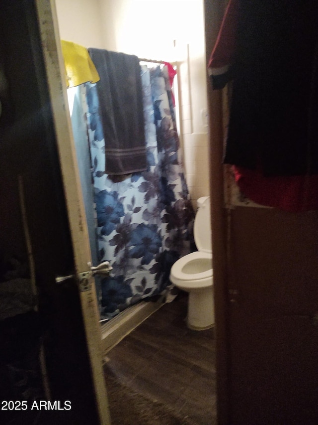 bathroom featuring curtained shower and toilet