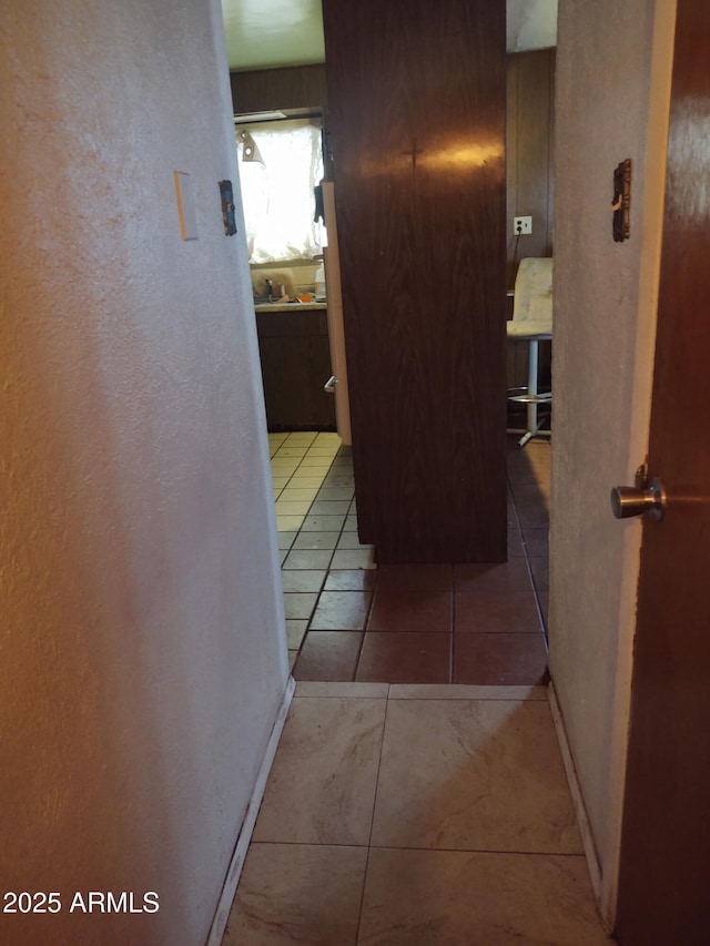 hallway with sink and light tile patterned floors