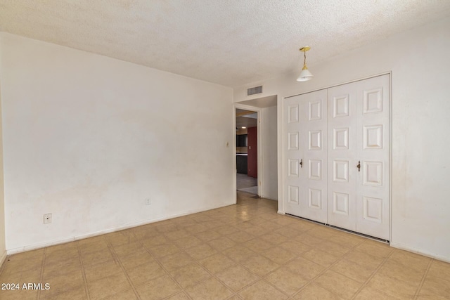6120 N 30th Ave, Phoenix, AZ 85017 - unfurnished bedroom featuring a textured ceiling, a closet, light flooring, and baseboards