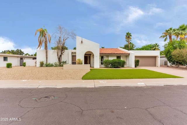8411 E Via De Jardin, Scottsdale, AZ 85258 - mediterranean / spanish-style home with a garage, concrete driveway, stucco siding, a front yard, and a tile roof