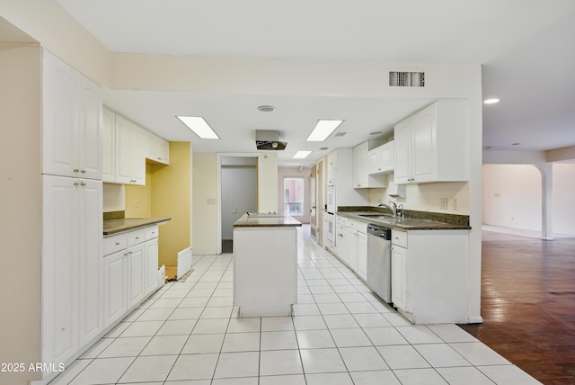 8411 E Via De Jardin, Scottsdale, AZ 85258 - kitchen with dark countertops, stainless steel dishwasher, a kitchen island, white cabinetry, and light tile patterned floors