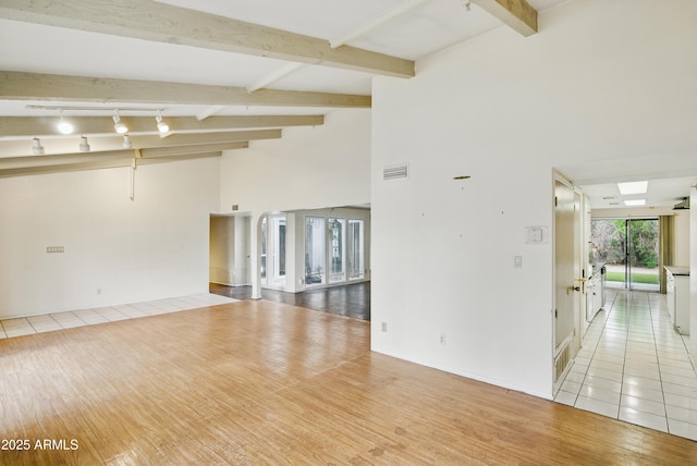 8411 E Via De Jardin, Scottsdale, AZ 85258 - empty room featuring wood finished floors, beamed ceiling, a towering ceiling, and rail lighting