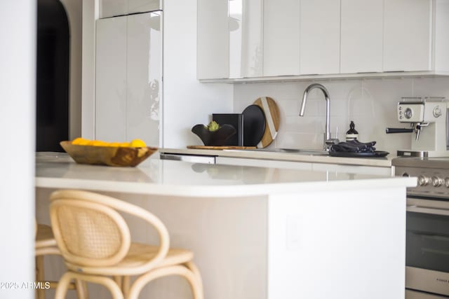 312 E Windsor Ave Unit 6, Phoenix, AZ 85004 - kitchen with stainless steel electric range oven, tasteful backsplash, white cabinetry, and light countertops