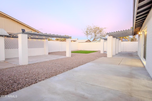 patio terrace at dusk featuring a pergola