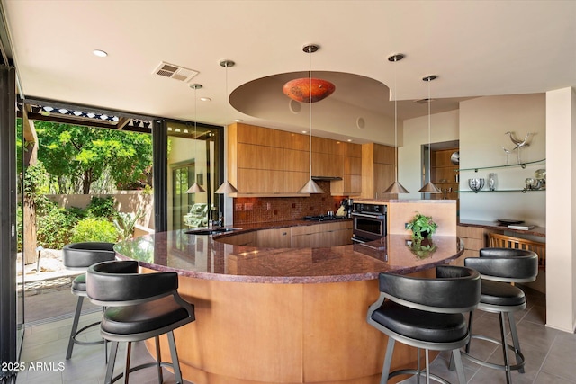 3120 Arroyo Hondo, Carefree, AZ 85377 - kitchen featuring gas stovetop, oven, visible vents, tile patterned flooring, and modern cabinets