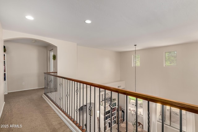 hallway with arched walkways, recessed lighting, baseboards, and carpet floors