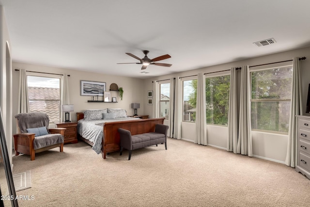 bedroom with light carpet, visible vents, and a ceiling fan