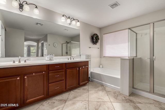 full bathroom with double vanity, visible vents, a stall shower, and a sink