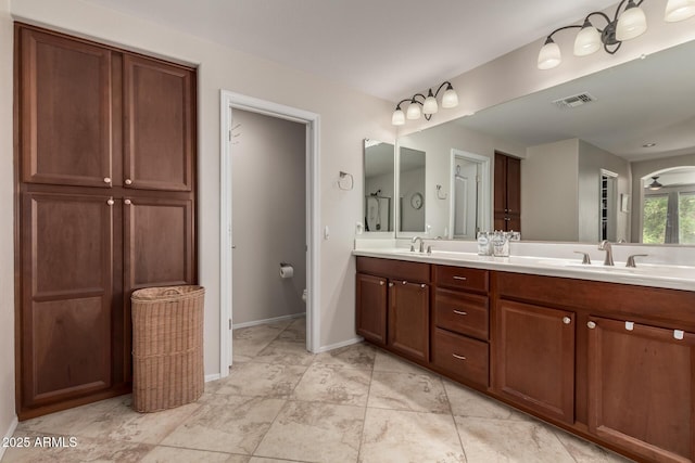 full bath with double vanity, visible vents, baseboards, and a sink