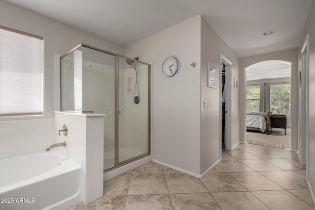 ensuite bathroom with ensuite bath, a bath, a stall shower, and tile patterned floors