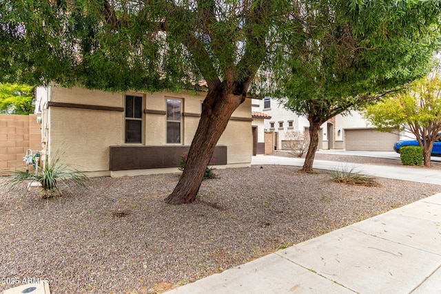 view of front of house with stucco siding and fence