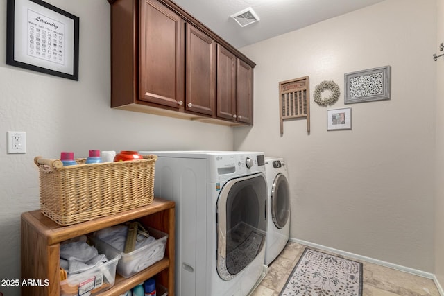 clothes washing area with cabinet space, visible vents, washing machine and dryer, and baseboards