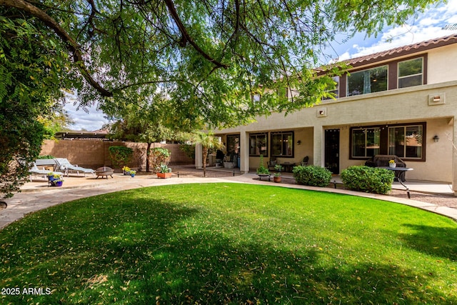 back of property with a patio, fence, a lawn, and stucco siding