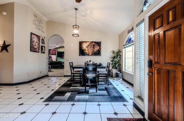 tiled dining room featuring lofted ceiling