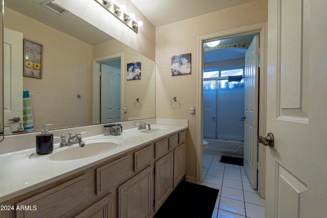 full bathroom with tile patterned floors, toilet, vanity, and combined bath / shower with glass door