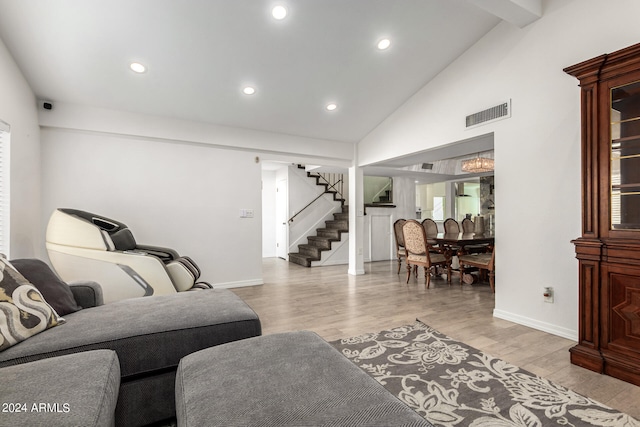 living room featuring high vaulted ceiling and light hardwood / wood-style flooring